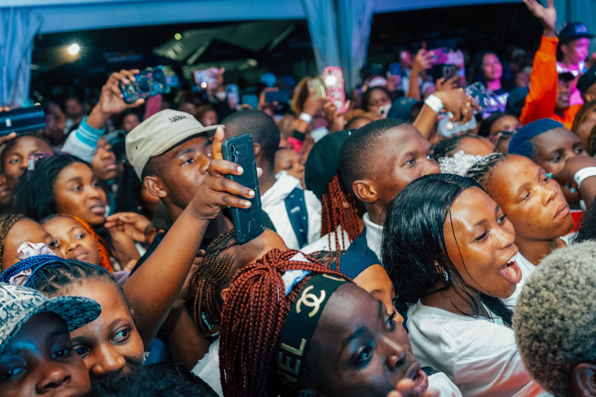 Dense festival crowd lit by stage lights